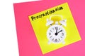Procrastination, delay, urgency concept. White alarm clock with text procrastination