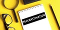 Procrastination. Motivation. Concept meaning delay or put off something boring written on a notepad on a yellow desk. View from Royalty Free Stock Photo