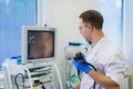 Proctologist holding an anoscope against a proctological chair. In the hospital