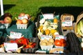 A produce farm stand with apples, tomatoes and pred peppers.