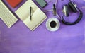 Producing podcast with stylish headphones,vintage microphone,coffee,smartphone,computer keyboard on purple table.Flat lay with