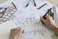 Product designer sketching concepts for a chair with pens and drawing instruments