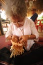 Product by hand made, hand of Senior Ethnic woman holds took bamboo stripes to weave into different. Royalty Free Stock Photo