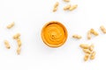 Product for hearty breakfast. High-calorie product. Peanut butter in bowl near nuts in shell on white background top Royalty Free Stock Photo