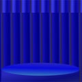 A blue stage with spotlighting is set against a backdrop of vertical, evenly spaced blue curtains. Royalty Free Stock Photo