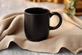 Product presentation, black coffee mug mockup on linen napkin Empty mug Royalty Free Stock Photo