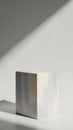 Minimalist White Cube on a White Surface with Dramatic Diagonal Shadow and Soft Lighting Creating a Clean Studio Product Display Royalty Free Stock Photo