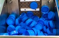 Production and bottling of yogurt or milk. Plastic blue cups. Equipment at the dairy plant.