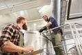 Men with clipboard at brewery or beer plant kettle Royalty Free Stock Photo
