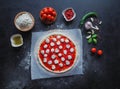 Production of Italian pizza Margarita. Stage of production. Tomato sauce, mozzarella cheese and tomatoes. Royalty Free Stock Photo