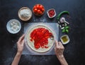 Production of Italian pizza Margarita. Stage of production. Tomato sauce, mozzarella cheese and tomatoes. Royalty Free Stock Photo