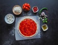 Production of Italian pizza Margarita. Stage of production. Tomato sauce, mozzarella cheese and tomatoes. Royalty Free Stock Photo