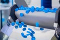 Production line - many blue plastic bottle caps falling from conveyor belt