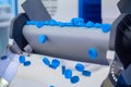 Production line - many blue plastic bottle caps falling from conveyor belt