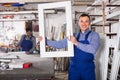 Production workers in coverall with different finished PVC profiles and windows at factory Royalty Free Stock Photo