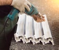 Production of pvc windows, man fastens metal profile to plastic, close-up, to a screwdriver, plastic