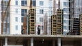 Production of structures made of rebar and concrete during the construction of a new house with silhouettes of workers.