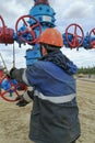 A production worker working with a gate valve on a well.