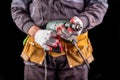 Production worker with tool belt. Drill in the hand of an employee Royalty Free Stock Photo