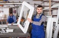 Production workers in coverall with different finished PVC profiles and windows at factory Royalty Free Stock Photo