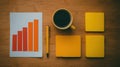 Desk workspace with colorful charts, coffee, and sticky notes for productivity tracking Royalty Free Stock Photo