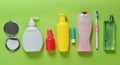 Products for beauty, self-care and hygiene on a green pastel background. Shampoo, perfume, lipstick, shower gel, toothbrush.