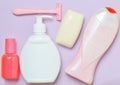 Products for the care of body, hair and personal hygiene on a purple pastel background. A bottle of fragrant perfume, lotion.