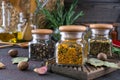 Products for cooking in kitchen, kitchen utensils, herbs, colorful dry spices in glass jars on dark