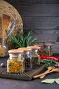 Products for cooking in kitchen, kitchen utensils, herbs, colorful dry spices in glass jars on dark Royalty Free Stock Photo