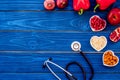 Products good for heart and blood vessels. Vegetables, fruits, nuts in heart shaped bowl near stethoscope on blue wooden Royalty Free Stock Photo