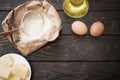 the products for its preparation dough on dark wooden background