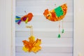 Products made of paper on window. Child creativity on the window. Paper birds and a leaf on a white window. Art of kids Royalty Free Stock Photo