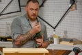 Profession, carpentry, woodwork and people concept - carpenter adjusts the drill before work at workshop