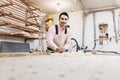 Carpenter working with plane and wood plank at workshop