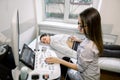 Professiona woman sonographer therapist working with ultrasound machine at the clinic, making kidney ultrasound for Royalty Free Stock Photo