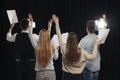 Professional actors bowing on stage in theatre, back view