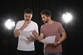 Professional actors reading scripts during rehearsal in theatre