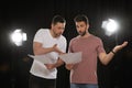 Professional actors reading their scripts during rehearsal in theatre