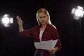 Professional actress reading script during rehearsal in theatre