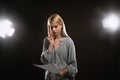 Professional actress reading script during rehearsal in theatre