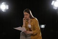 Professional actress reading script during rehearsal in theatre