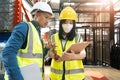 Professional adult Asian male warehouse manager and female worker are working together, checking their inventory in the Royalty Free Stock Photo