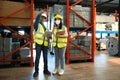 Professional adult Asian male warehouse manager and female worker are working together, checking their inventory in the Royalty Free Stock Photo