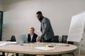 Professional African male mentor training middle-aged female employee in office. Businessman manager talking to Royalty Free Stock Photo