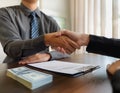 Professional agent and client interaction featuring elements like a handshake, business card, and contract symbolizing