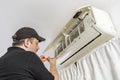 Professional air conditioning technician removing the screws to disassemble the housing of an internal unit of a split air system