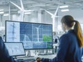 A professional analyzing data related to renewable energy systems and wind turbines on multiple computer screens
