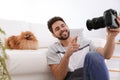 Professional animal photographer taking selfie with Pomeranian spitz dog indoors