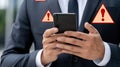 A professional appears anxious while checking a warning message on his phone, surrounded by coding screens in a