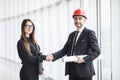 Professional architect and businesswoman handshake against panoramic window in office. Royalty Free Stock Photo